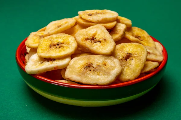 健康的甜小吃 清脆的脱水香蕉片在碗中的绿色背景 — 图库照片