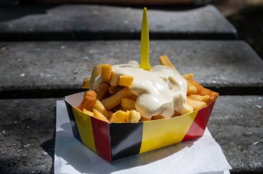 Belçika caddesi ve fast food, Belçika bayrağı renginde kağıt kutu kızarmış patates cipsi ve mayonez.