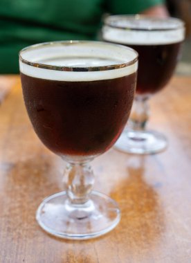 Soğuk koyu Belçika manastırı biralı bardaklar açık havada servis edilir.