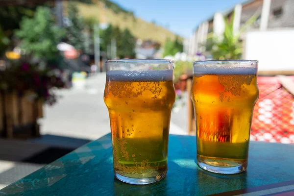 French cold beer in misted glasses served on outdoor terrace in small Alpine village in France close up