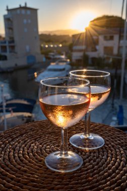 Yazın günbatımında yerel soğuk gül şarabı içmek arka planda liman, Provence, Var, Fransa