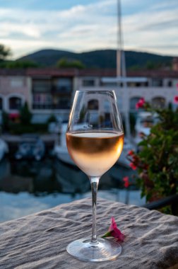 Yaz günbatımında yerel soğuk gül şarabının tadına bakmak arka planda liman, Provence, Var, Fransa