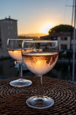 Yazın günbatımında yerel soğuk gül şarabı içmek arka planda liman, Provence, Var, Fransa