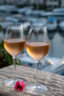 Yaz günbatımında yerel soğuk gül şarabının tadına bakmak arka planda liman, Provence, Var, Fransa