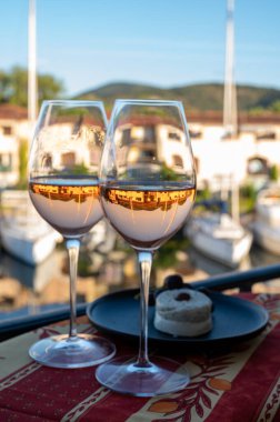 Yaz aylarında yerel gül şarabı ve yumuşak Fransız keçi peyniri tatmak ve arka planda Port Grimaud limanı, Provence, Var, Fransa