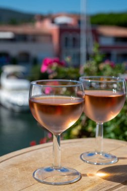 Yaz mevsiminde yerel soğuk gül şarabının tadına bakmak arka planda liman grimaud limanı, Provence, Var, Fransa