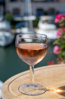 Yaz mevsiminde yerel soğuk gül şarabının tadına bakmak arka planda liman grimaud limanı, Provence, Var, Fransa