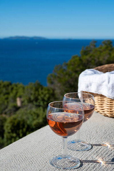 Drinking of local cold rose wine at sunset in summer with sail boats haven of Port grimaud on background, Provence, Var, France