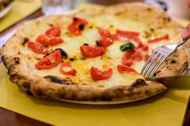 İtalyan pizzası, mozzarella peyniri, küçük kırmızı domates ve taze fesleğen.