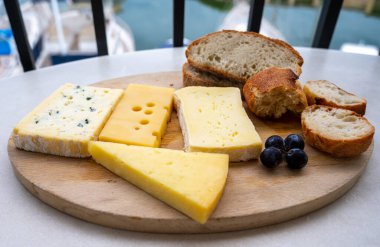 Mermer tahtada Fransız peyniri koleksiyonu, emmental, carre de aurillac, petit cantal AOP Jeune, buche chevre ve brie