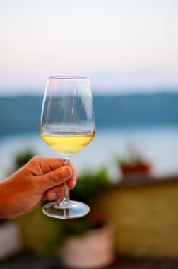 İtalya 'da gece vakti kafede servis edilen bir bardak soğuk beyaz şarapla el sıkışın.