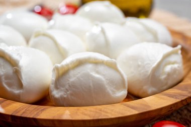 Lezzetli İtalyan yemekleri, taze beyaz bufalo mozzarella yumuşak peynir topları Campania ve domatesler, taze fesleğen ve zeytinyağı, yakın çekim.