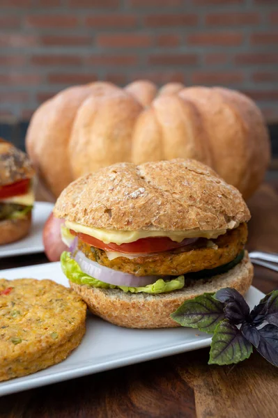 Making fresh and healthy vegetarian hamburgers with grilled pumpkin burgers, organic buns and vegetables close up