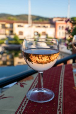 Yaz mevsiminde yerel soğuk gül şarabı içerken arka planda liman, Provence, Var, Fransa