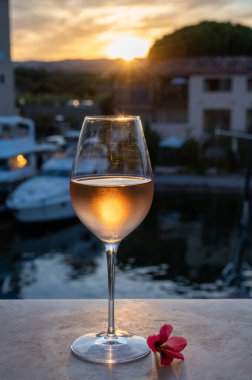 Yaz günbatımında yerel soğuk gül şarabının tadına bakmak arka planda liman, Provence, Var, Fransa