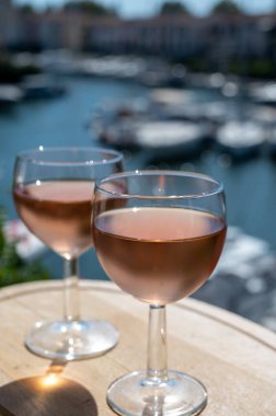 Yaz mevsiminde yerel soğuk gül şarabının tadına bakmak arka planda liman grimaud limanı, Provence, Var, Fransa