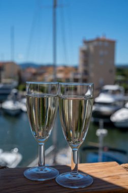 Arka planda Port Grimaud, Var, Provence, Fransa 'nın şampanyalı şarabı ve yelkenli cenneti olan yaz partisi