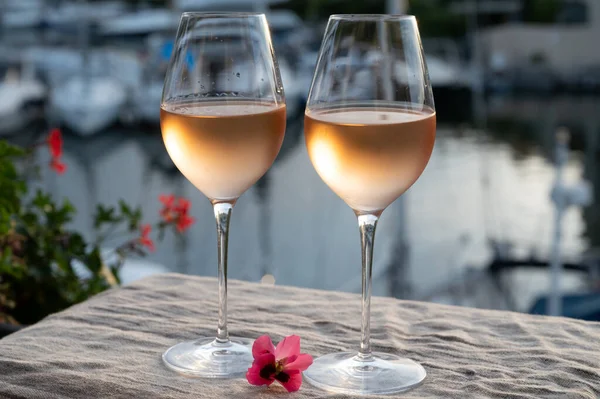 stock image Tasting of local cold rose wine in summer on sunset with sail boats haven of Port grimaud on background, Provence, Var, France