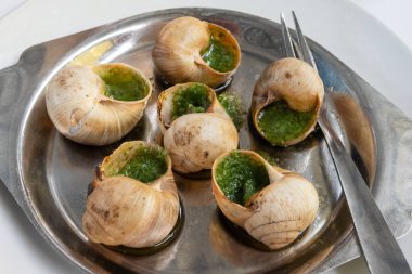 Burgundy 'den maydanozlu salyangoz ve sarımsaklı tereyağı ile fırın Toulouse veya Paris' teki Fransız restoranında başlangıç yemeği olarak servis edilir.