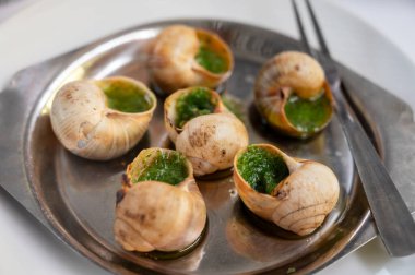 Burgundy 'den maydanozlu salyangoz ve sarımsaklı tereyağı ile fırın Toulouse veya Paris' teki Fransız restoranında başlangıç yemeği olarak servis edilir.