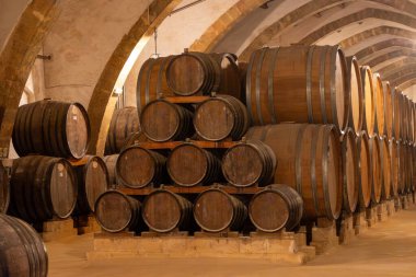 Eski büyük meşe fıçılarıyla şarap mahzeni ziyareti, Marsala, Sicilya 'da güçlendirilmiş kuru veya tatlı marsala şarabı üretimi, İtalya' da şarap endüstrisi