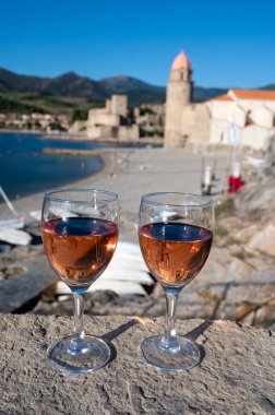Eski Collioure kasabası manzaralı iki bardak gül Collioure AOC şarabı, renkli evler, kilise, kale ve plajlar, Occitanie, Fransa, turist beldesi