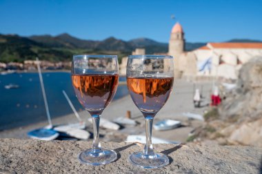 Eski Collioure kasabası manzaralı iki bardak gül Collioure AOC şarabı, renkli evler, kilise, kale ve plajlar, Occitanie, Fransa, turist beldesi
