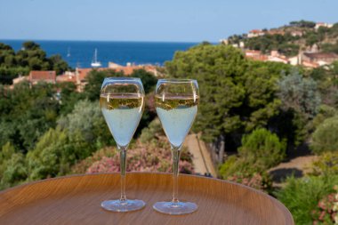 Akdeniz 'de yaz tatili, soğuk, köpüklü şampanya içmek, güneş ışığı ve deniz manzaralı kava şarabı, Collioure, Occitanie, Güney Fransa, turist beldesi
