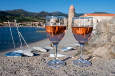 Eski Collioure kasabası manzaralı iki bardak gül Collioure AOC şarabı, renkli evler, kilise, kale ve plajlar, Occitanie, Fransa, turist beldesi