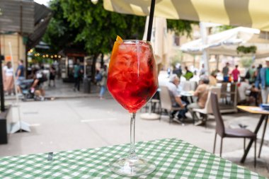 Spritz Campari, likör, şarap, buz küpleri ve bir parça portakal, Palermo, Sicilya, İtalya 'nın sokak manzaralı sert, uzun bir kokteyl kızı.