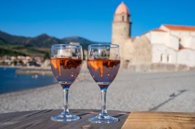 Eski Collioure kasabası manzaralı iki bardak gül Collioure AOC şarabı, renkli evler, kilise, kale ve plajlar, Occitanie, Fransa, turist beldesi