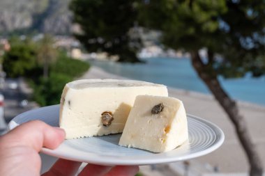 Primo İndirimli Sert Peynir. Karışık sütten yapılmış. Sicilya sepetinin ince kabuğu ve deseni turşulu kapari ve Sicilya, Mondello sahilinde deniz manzaralı.