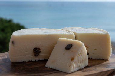 Primo İndirimli Sert Peynir. Karışık sütten yapılmış. Sicilya sepetinin ince kabuğu ve deseni turşulu kapari ve Sicilya, Mondello sahilinde deniz manzaralı.