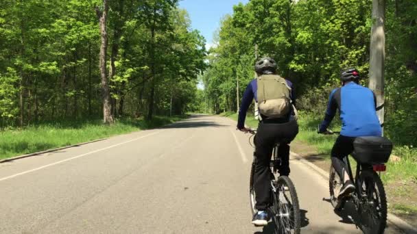 Dva Cyklisté Jezdí Podél Uličky Letního Parku — Stock video