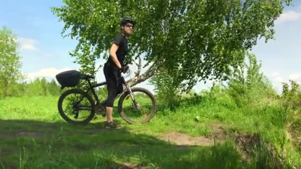 Νεαρή Γυναίκα Ιππεύει Ένα Ποδήλατο Μέσα Από Πάρκο Στο Φόντο — Αρχείο Βίντεο