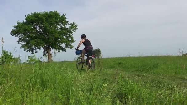 農場に沿って移動する自転車に乗った女の子観光客 — ストック動画