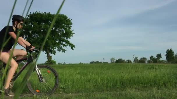 農場に沿って移動する自転車に乗った女の子観光客 — ストック動画