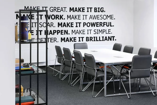 会議室 ミーティング テーブルやオフィスのアームチェア 壁にモチベーションの言葉で — ストック写真