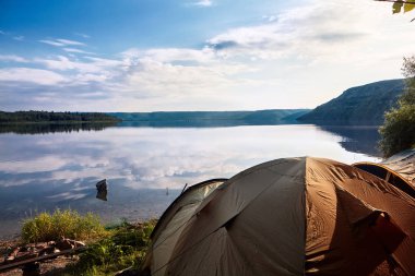manzara nehir kamp çadır ilk planı ve nehir yansıma bulutların üzerinde geniş açı ile. Reflection.Cloydu gökyüzü. Seyahat