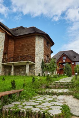 Küçük ahşap ev ahşap güdük oluşan yol. Yeşil çim. Bulutlu gökyüzü. Arka plan