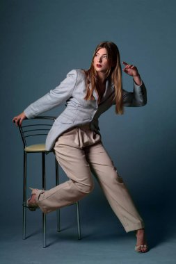 Bir ışık mavi ceketli blondy saçlı güzel moda kız. Kız bir açık mavi renkli olarak stüdyoda. Reklam, ürünleri, güzellik salonları, kozmetik, giyim. Moda, butik. Açık mavi. Moda.