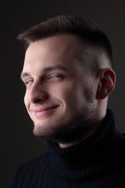 Genç adam portre siyah arka plan üzerine kapatın. Utangaç.