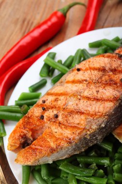 Somon steak Frenk soğanı fasulyeli ızgara. Deniz tuzu. Ahşap masa üzerinde. Biber biber. Portre.