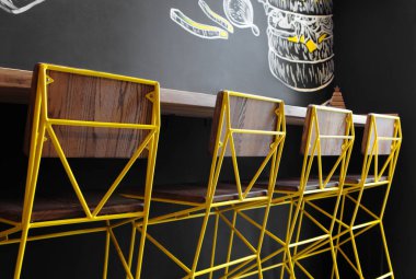 Kafenin iç sandalye Cloesup . Çatı alanı tasarımı, ahşap masa, beton duvar. yaratıcı minimalist kafe iç, basitlik ve geometri kavramı, siyah ve sarı renkler. Yaratıcı alan