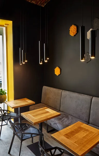 Interior of cafe . Loft space design, wooden table, concrete wall. creative minimalistic cafe interior, simplicity and geometry concept, black and yellow colors.Creative space