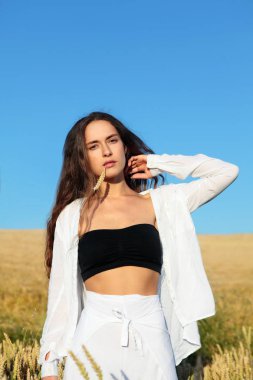 Şık beyaz pantolon ve siyah üst ve beyaz gömlek uzun saçlı güzel kız. Uzun saçlı, kıvırcık kız. Şık kız. Çavdarlı kız. Alanında güzel bir kız yaz fotoğrafları