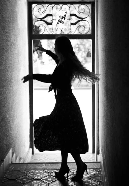 Silhouette of dancing girl in coridor. Black and white Стоковое Изображение