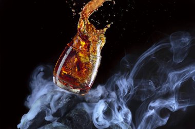 Bir bardak viski Splash. Sis ve siyah arkaplanlı, taştan yapılmış yaratıcı bir viski bardağı. Anlaşıldı.