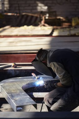 Kaynakçı elektrot ile yarı otomatik ark imalat üretim tesisinde çalışan