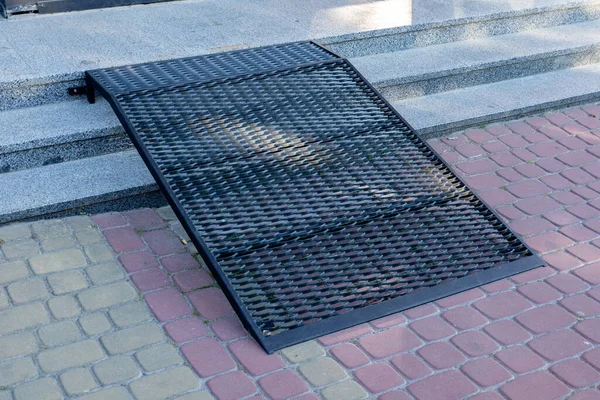 Binanın girişindeki bir metal rampa engelliler için hareket ve erişilebilirliği artırır.